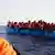Several people await rescue on a rubber boat in the Mediterranean