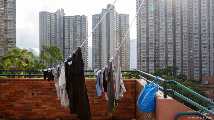 Washed clothes are dried on a rope against the backdrop of Hong Kong's skyscrapers