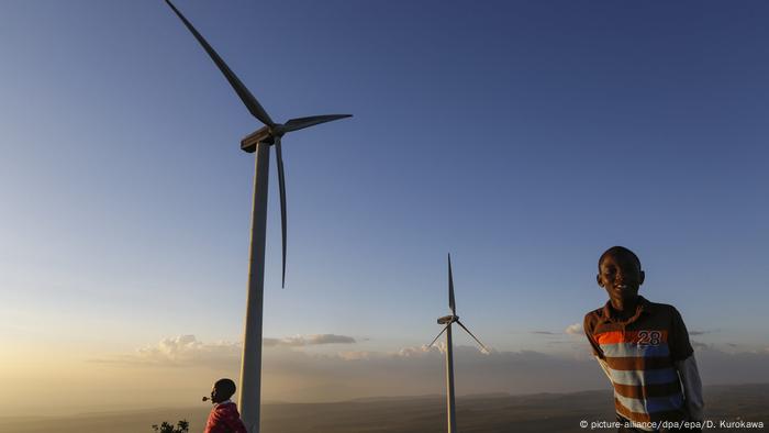 Children play near wind turbines in Kenya