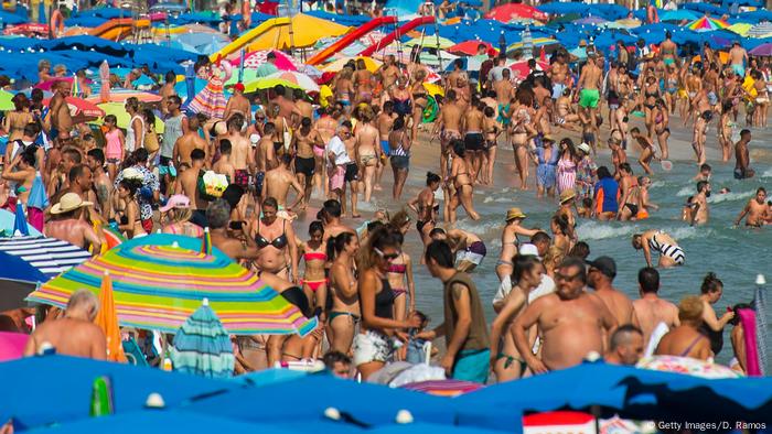 People sunbathe at Levante Beach in Benidorm, Spain