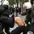 Polizisten in Helm und Uniform versuchen einen Demonstranten abzuführen (Quelle: AP)
