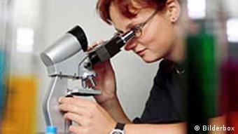 Frau im Labor mit Mikroskop