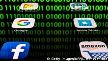 This illustration picture taken on April 20, 2018 in Paris shows apps for Google, Amazon, Facebook, Apple (GAFA) and the reflexion of a binary code displayed on a tablet screen. (Photo by Lionel BONAVENTURE / AFP) (Photo credit should read LIONEL BONAVENTURE/AFP/Getty Images)