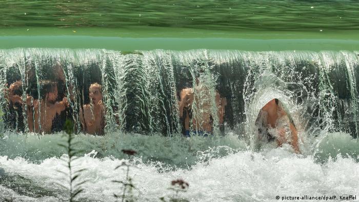 July 24, 2019: children cool off in Munich's English Garden waterway