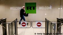 A picture taken on June 8, 2018 shows a man as he walks past a control post of the Russia Today (RT) TV company in Moscow. (Photo by Yuri KADOBNOV / AFP) (Photo credit should read YURI KADOBNOV/AFP/Getty Images)