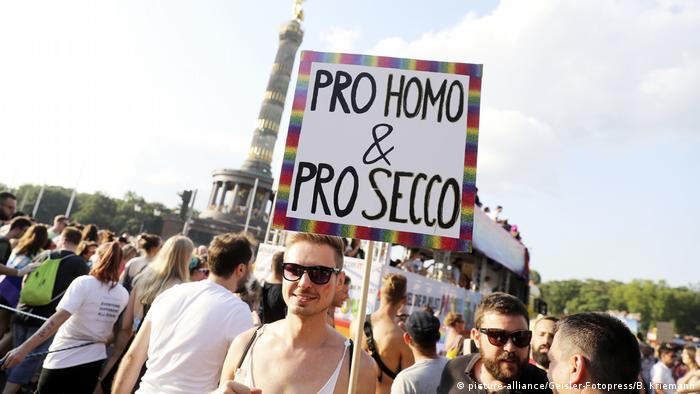 Demonstrierende halten ein Schild mit der Aufschrift Pro Homo & Pro Secco.