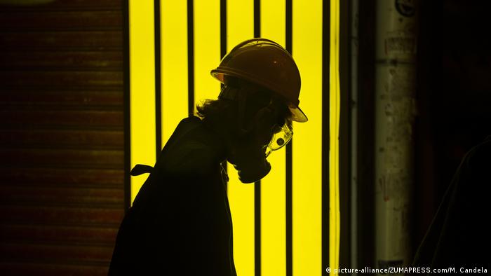 A protester walks in front of a yellow light