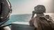 A US soldier observes a nearby boat while transiting through the Strait of Hormuz A US soldier observes a nearby boat while transiting through the Strait of Hormuz