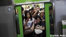 In this picture taken on July 18, 2019 passengers get off the train at Shinagawa station in Tokyo. - Japan's workers spend more hours at the office than employees in almost any other country. But to avoid traffic chaos at next year's Olympics, authorities have a message: stay home. Hundreds of thousands of people are expected to attend Olympic and Paralympic events in Tokyo during the 2020 Games, putting additional strain on the city's already notoriously crowded commuter routes. (Photo by Behrouz MEHRI / AFP) / TO GO WITH AFP STORY: Olympics-2020-Tokyo-transport-lifestyle, FOCUS by Kyoko HASEGAWA