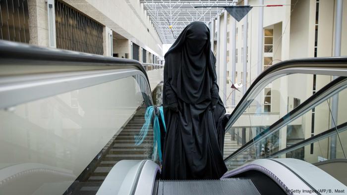Niederlande Den Haag | Frau mit Burka auf Rolltreppe