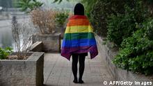 In this photo taken on May 10, 2019, a gay student poses with a rainbow flag in Beijing. - China's LGBT community has had a tough year: Censors have shut down some of its social media forums, online news media have curbed coverage of gay issues, and online shops have removed sales of rainbow-themed products. The tighter restrictions have led the LGBT community in China -- fearing a crackdown -- to prepare for muted celebrations of the International Day Against Homophobia, Transphobia and Biphobia on May 17. (Photo by GREG BAKER / AFP) / TO GO WITH China-gay-rights, FOCUS by Pak YIU (Photo credit should read GREG BAKER/AFP/Getty Images)