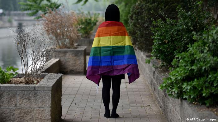 2019年5月10日拍摄的这张照片中，一名中国同志学生在北京披上彩虹旗。 中国LGBT社群在2019经历了艰难的一年，审查机构关闭了一些社交媒体论坛，网络新闻媒体限制了对同志的报道，网络商店停止销售彩虹主题产品。 