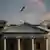Приспущенный флаг США на крыше Белого дома в Вашингтоне