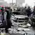Polizist vor zerstörtem Auto (Foto: AP)