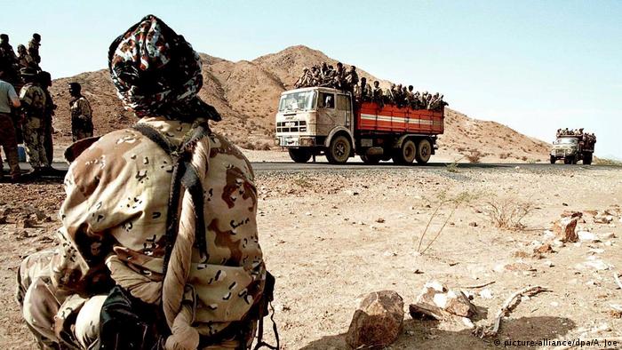 Eritreischer Soldat beobachtet Soldaten auf Lastwagen auf dem Weg nach Akurdet (picture-alliance/dpa/A. Joe)