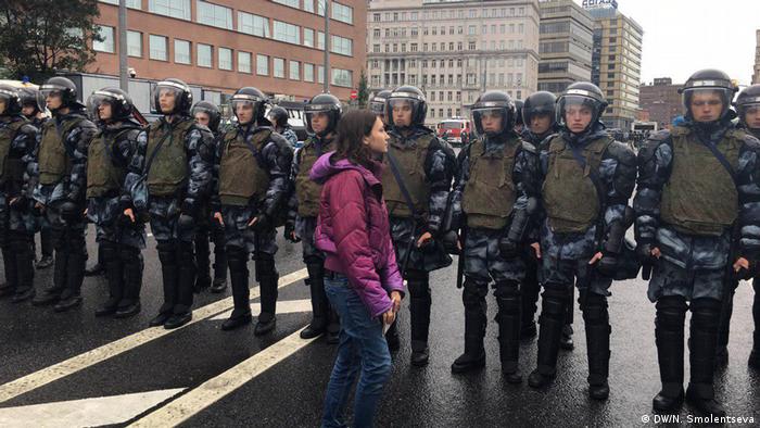 Девушка перед полицейским кордоном 