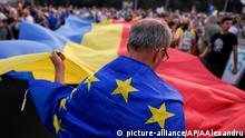 10.08.2019, People hold European Union and Romanian flags during an anti-government protest in Victoria Square, outside the government headquarters in Bucharest, Romania, Saturday, Aug. 10, 2019. Thousands joined a protest, demanding the resignation of the government, one year after a similar rally turned violent and left dozens of participants and members of the riot police injured.(AP Photo/Andreea Alexandru)