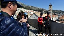 Tourists take selfie pictures with their mobile phones on the fortification of the old town in Dubrovnik, Croatia, on March 28, 2019. - Shepherding tourists through the arches and towers of Croatia's mediaeval walled city of Dubrovnik, Ivan Vukovic spends half of his time leading tours of a capital that doesn't exist: the fictional King's Landing from Game of Thrones. The two cities are starting to rival each other for fame after Dubrovnik -- already a tourist and cruise-ship magnet -- became a set for the cult HBO series, whose final season starts on April 14. This new layer of publicity can be a blessing and it can be a curse, said 38-year-old tour guide Vukovic. (Photo by Denis LOVROVIC / AFP) (Photo credit should read DENIS LOVROVIC/AFP/Getty Images)