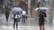 Pedestrians in Japan hold umbrellas in strong wind from tropical storm Krosa Pedestrians in Japan hold umbrellas in strong wind from tropical storm Krosa