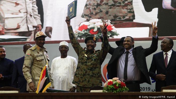 Military and civilian leaders celebrate the signing of the transitional deal 