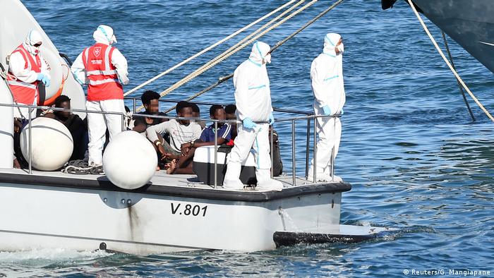 Several migrant minors sitting on an official Italian boat before disembarking