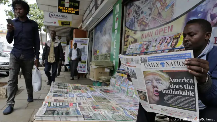 A man reads the daily nation newspaper at a newsstand in Nairobi