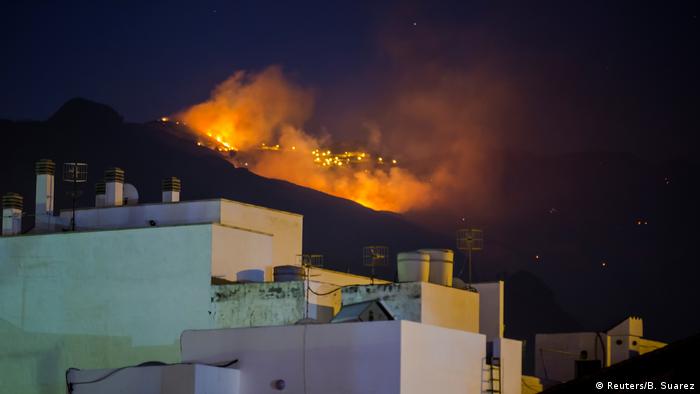 A wildfire burns behind houses on the Spanish island of Gran Canaria