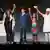 Young speakers hold up their hands on stage at the Religions for Peace 10th World Assembly