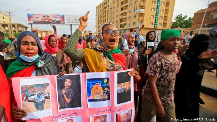 Mulheres sudanesas exibem fotos de manifestantes mortos durante os protestos em Cartum