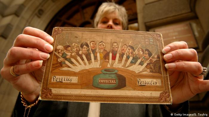 Großbritannien 2002 | eine Frau hält die alteste Postkarte der Welt von Theodore Hook hoch