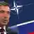 Rasmussen in front of a montage of the NATO and Russian flags
