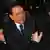 Italian Prime Minister Silvio Berlusconi is pictures in his car, after a young man struck him in the face in a Milan square