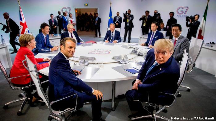 Emmanuel Macron and other leaders sit at a round table alongside Donald Trump during a G7 meeting