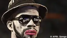 A fan wearing face-paint attends the funerals of DJ Arafat at the Felix Houphouet-Boigny stadium in Abidjan on August 30, 2019. - Thousands of fans gathered on August 30, 2019 to pay tribute toDJ Arafat, an Ivorian singer with a huge following in francophone Africa that died at the age of 33, on August 12, after a road motorbike accident in Abidjan, evoking a wave of tributes to the award-winning star of the coupe-decale dance genre. (Photo by ISSOUF SANOGO / AFP)