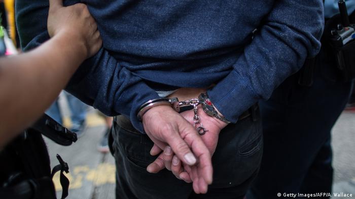 Symbolbild China Verdächtiger in Handschellen