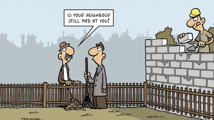 Fernandez cartoon: a man building a wall while two others talk at a fence