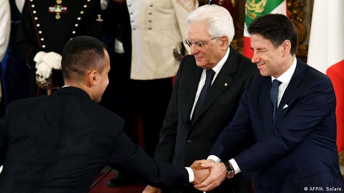 In Gegenwart von Präsident Mattarella schüttelt Premier Conte (r.) Sterne-Chef Di Maio die Hand
