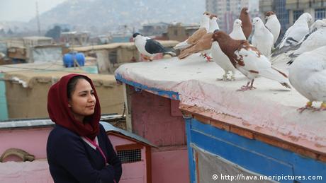 Film still from 'Hava, Maryam, Ayesha': a woman on a Kabul rooftop looking at pigeons.