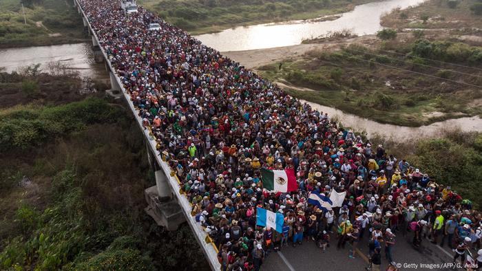 Migrantes pasando por un puente de camino a Estados Unidos.