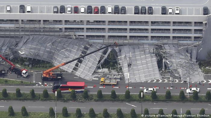 An aerial photo shows damaged temporary scaffold set outside of a parking building at Haneda Airport