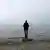 Junger Mann steht bei trübem Wetter an der Ostsee
