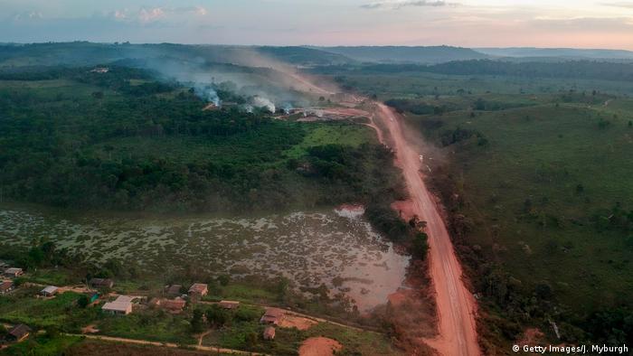 Red dust from the BR230 highway in the Amazon mixes with smoke from wildfires
