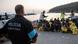 A policeman at the docks in Lesbos supervising a group of refugees