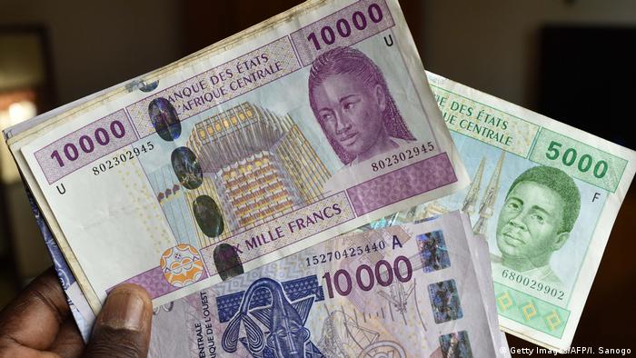 Hand holds various CFA franc notes