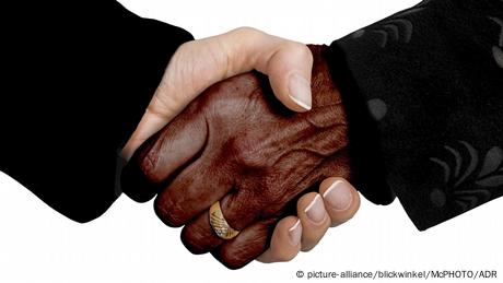 Duas mãos dadas, sendo uma negra e a outra, branca
