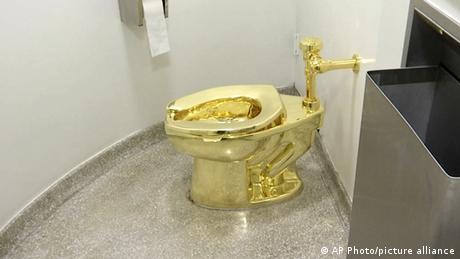 Golden toilet in a small bathroom 