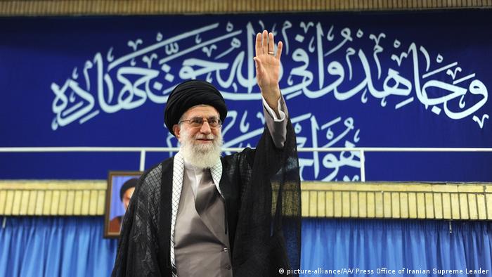 Iranian Ayatollah Ali Khamenei gestures on a stage 