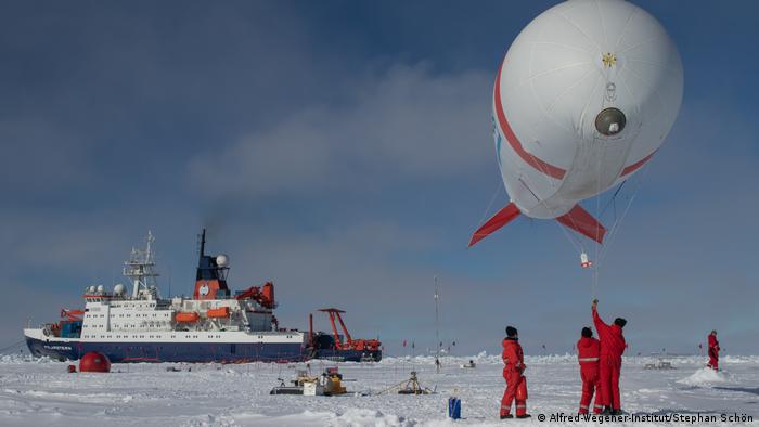 Researchers of the Polarstern vessel working outside on the ice
