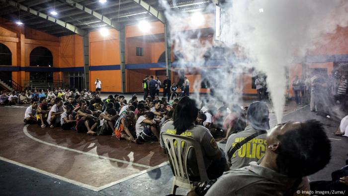 Police personnel smoke using e-cigarette while guarding the holding area