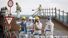 epa05152377 Workers wearing protective suits and masks stand near the No. 3 and No.4 reactor buildings at Tokyo Electric Power Co's (TEPCO) tsunami-crippled Fukushima Daiichi nuclear power plant in Okuma town, Fukushima prefecture, Japan, 10 February 2016. A group of foreign media visited to the plant, just a month before the fifth anniversary of the nuclear accident. The 9.0-magnitude earthquake that struck 11 March 2011 and triggered a tsunami claimed the lives of an estimated 15,000 people, and led to a nuclear accident on a level that had not been seen since Chernobyl in 1986. EPA/TORU HANAI / POOL |